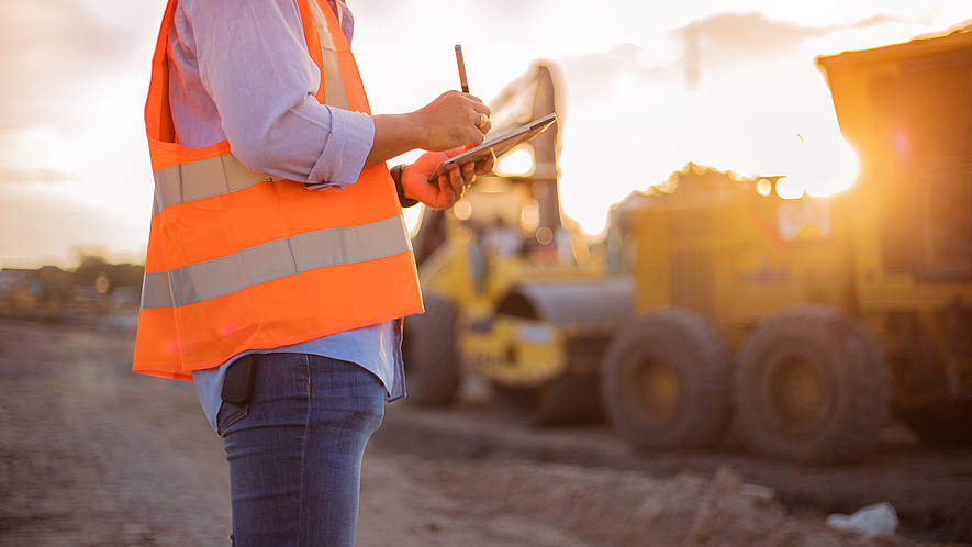 Bauarbeiter auf Baustelle Ein Bauarbeiter benutzt ein Tablet auf einer Baustelle.