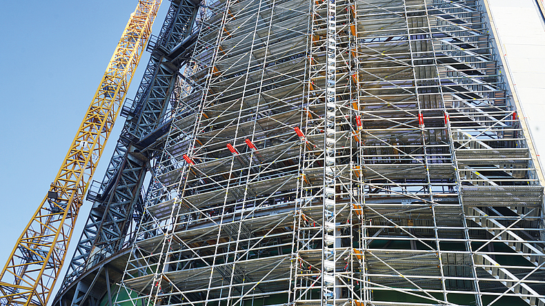 Seitenansicht des eingerüsteten Gasometers: Wie das Gerüst, so wächst auch die Einhausung von Stockwerk zu Stockwerk mit.
