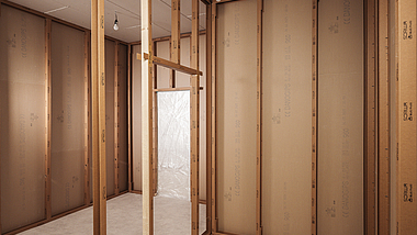 Innenansicht eines Raums im Holzrahmenbau mit freiliegenden Holzständern und Wandplatten im Rohbau.
