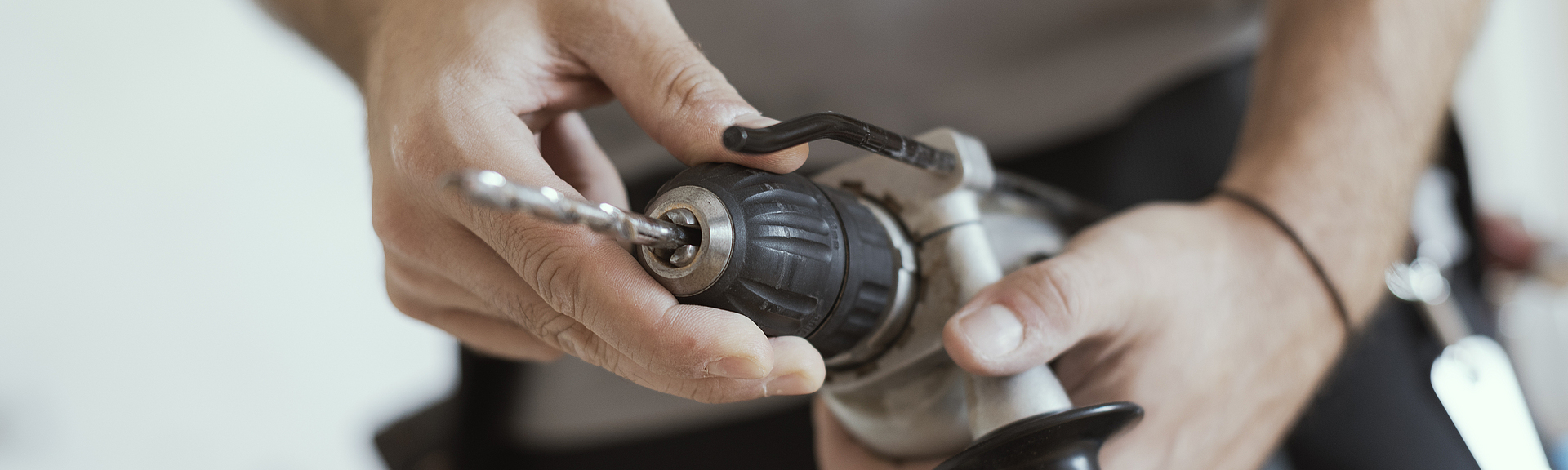 Handwerker wechselt Bohrer Ein Handwerker wechselt einen Bohrer.