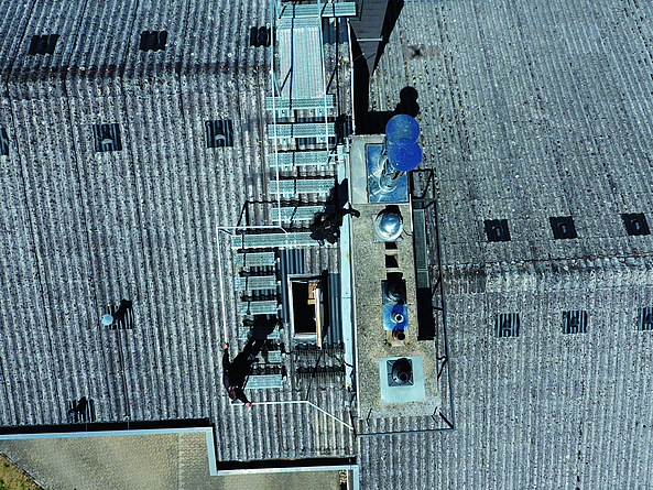 Blick von oben auf eine Dachfläche: An schwer zugänglichen Objekten inspizieren Drohnen Dachflächen und vermessen z. B. die Abstände von Heizungs- und Abgasanlagen zu Nachbargebäuden. Dies erleichtert die Arbeiten des Schornsteinfeger-Gewerks.