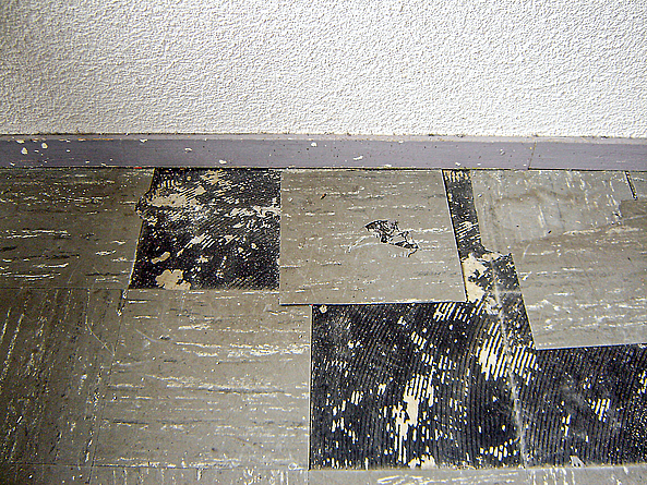 Kleber unter entfernten Fußbodenplatten.
