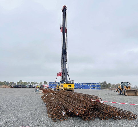 Seilbagger mit davor liegenden Bewehrungskörben vor dem Start der Arbeiten.
