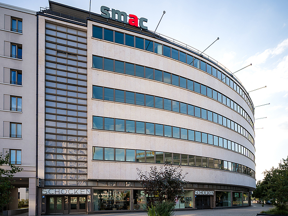 Halbrundes Gebäude, auf dem oben "smac" steht und der Schriftzug "Schocken" über dem Hauseingang.