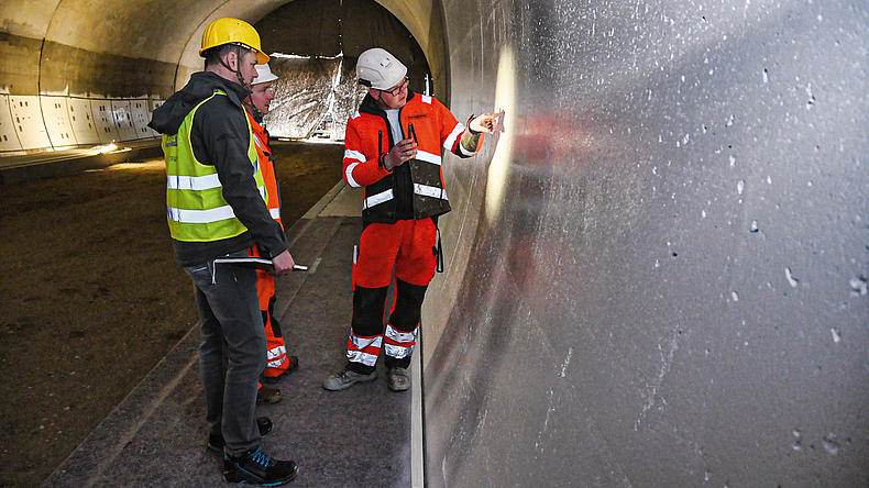 Personen überürfen die Abdichtung eines Tunnelbauwerks.