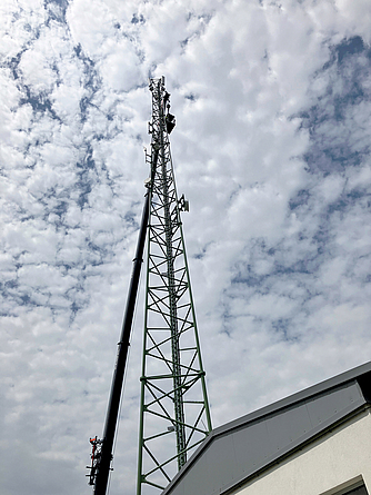 Richtfunkturm mit SensorBolts Richtfunkturm von unten nach oben fotografiert. Am Himmel sind viele Wolken zu sehen.