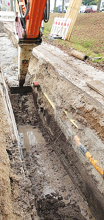 Wegen des anstehenden Grundwassers erfolgte auf 480 m die Grabenverfüllung mit Flüssigboden. In einen etwa 80 cm breiten Graben wird mit einer großen Spritze Flüssigboden eingefüllt.