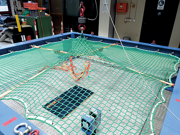 Ein Netz wurde in einen quadratischen Rahmen gespannt. Ein Quadrant des Netzes ist nach oben ausgelenkt.