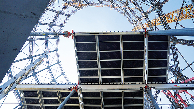 Blick von unten nach oben auf Gerüstlagen und Himmel.