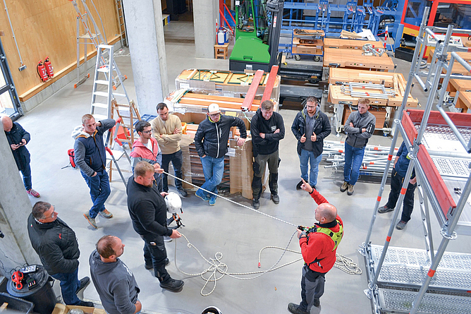 Klaus Heiligmann demonstriert die Nutzung der PSAgA. Demonstration der Funktion der PSA gegen Absturz vor einer Gruppe von Teilnehmern in der Trainingshalle des BZ Immenstadt.