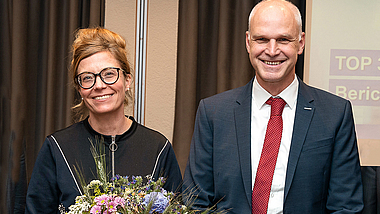 Katia-Julia Rostek mit Blumenstrauß links, rechts neben ihr Michael Kirsch