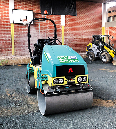Elektro-Walze bei Bodensanierung Sporthalle In einer Sporthalle, deren Boden aufgerissen ist und bearbeitet wird, steht eine Walze.