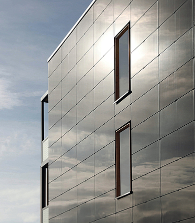Die nach Süden ausgerichteten Giebelwände wurden jeweils mit PV-Paneelen ausgestattet. Fassade aus Photovoltaikmodulen sowie außenstehende Etagengänge zum Fahrstuhlturm.