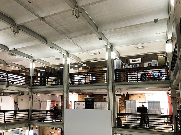 Blick auf die oberen Etagen im Kühlhaus Berlin, wo Aussteller ihre Lösungen präsentieren.