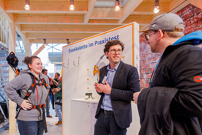 Demonstration des Einsatzes des Exoskeletts auf dem Stand der BG BAU.