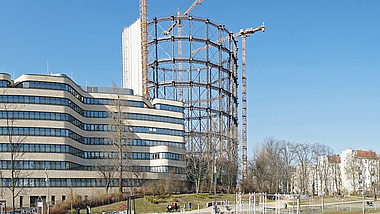 Panorama-Sicht auf das Baugelände, im Zentrum befindet sich das Gasometer im Bauzustand, daneben ein Kran.