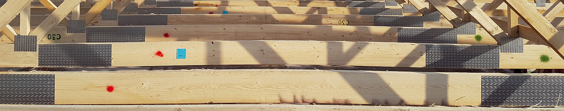 Viele dreieckige Nagelplattenbinder hintereinander auf einem Dach.