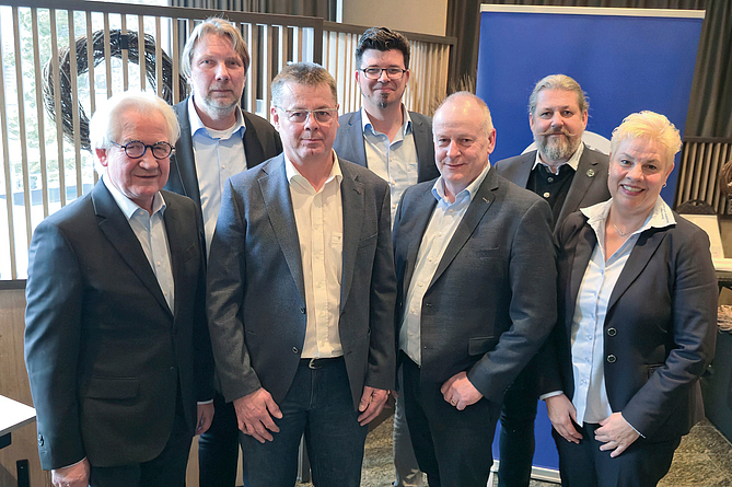 Gruppenbild mit sieben Personen in einem Innenraum.
