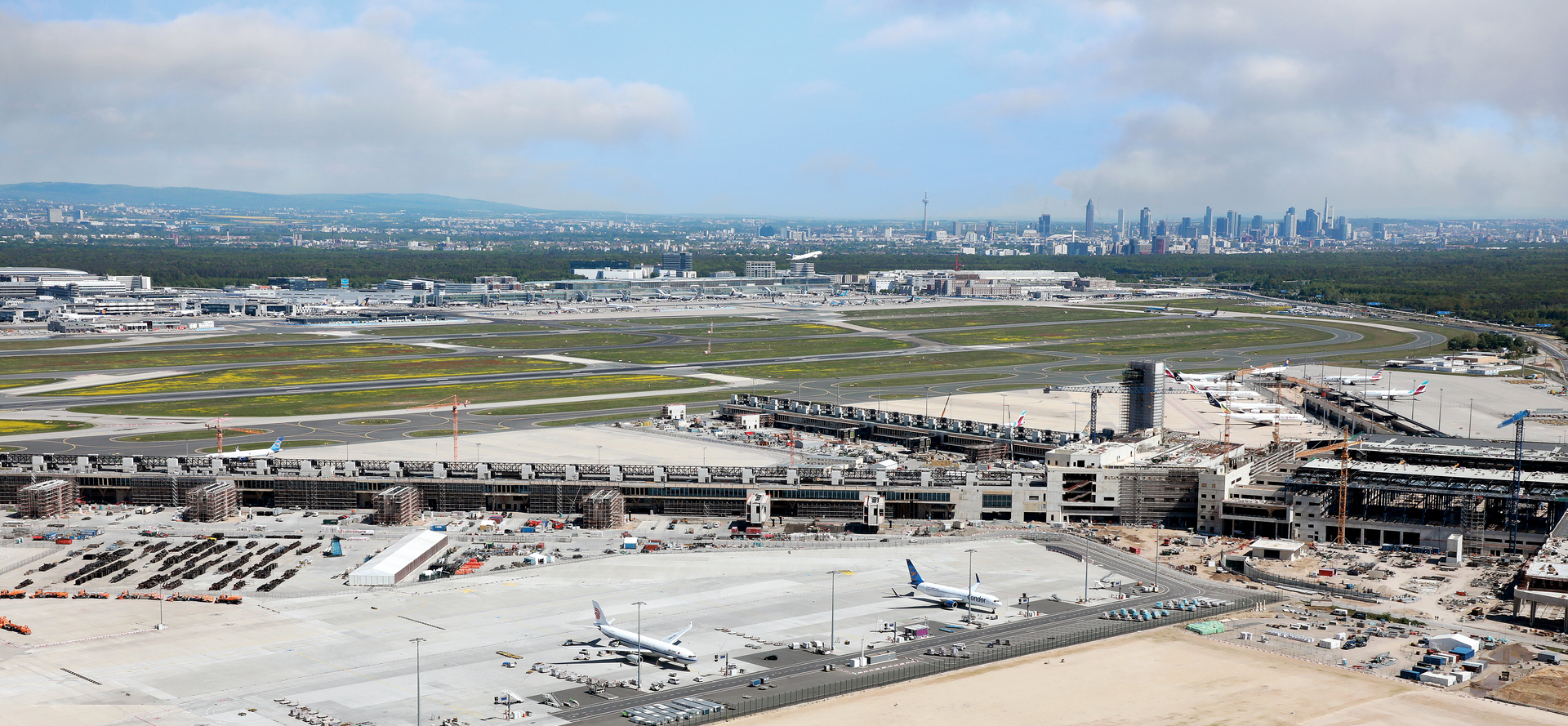 Panorama der Baustelle des Terminals 3 mit den Flugsteigen am Frankfurter Flughafen, im Hintergrund die Skyline von Frankfurt