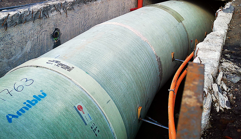 Aarsleff Rohrsanierung brachte im Görlitzer Pontekanal insgesamt 100 m GFK der Nennweite DN 2200 per Reliningverfahren ein. Mehrere Rohrstücke, zusammengesetzt in einer Grube, in Großaufnahme auf der Baustelle. Im Hintergrund ist der Kran zu sehen.