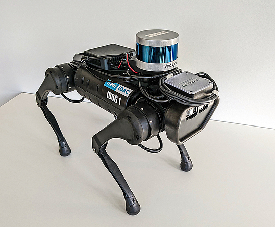 Im bauma FORUM wurde IDOG (kurz für Intelligent Documentation Gadget) im Rahmen des Vortrags „Legged robots in the construction industry – digital inspection and documentation on site“ vorgestellt. Schwarzer Roboterhund mit vier Beinen.