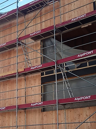 Holzfassade mit Gerüst.