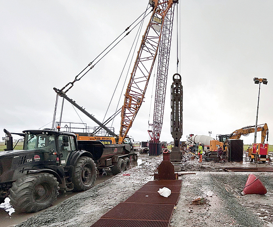 Baustelle mit Seilbagger mit Schlitzbandgreifer.