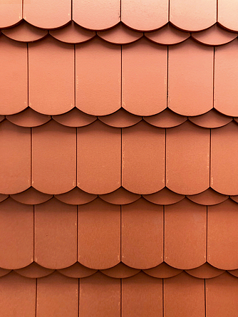 Naturrote Biberschwanzziegel auf dem Dach Detailaufnahme eine Dachstücks mit roten Ziegeln.