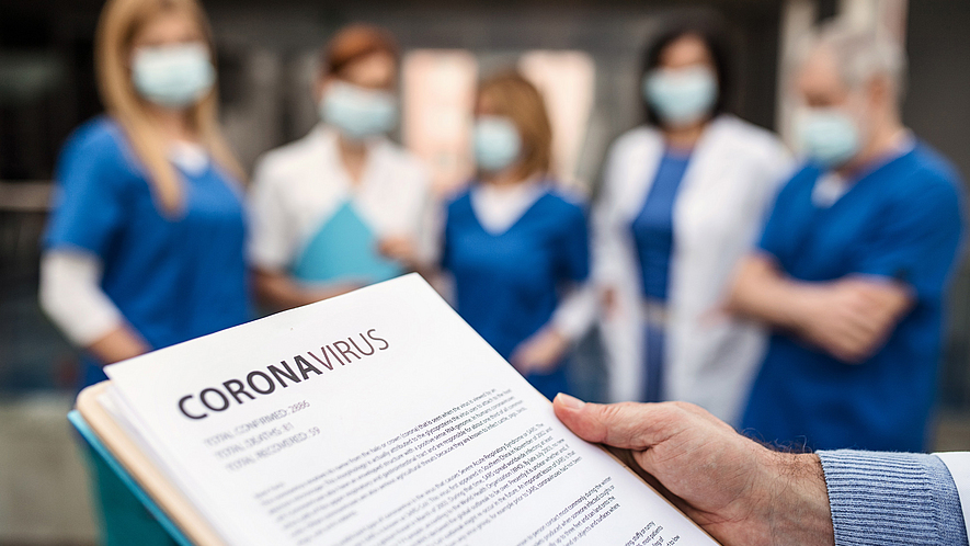 Eine Gruppe von medizinischem Personal diskutieren in einem Arbeitstreffen über das Coronavirus.