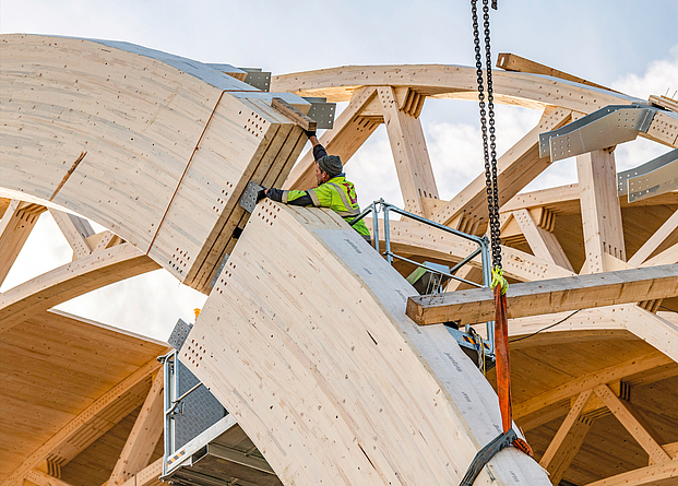 Zwei Gelenkbögen aus Fichtenholz werden miteinander verbunden. Die Knotenpunkte wurden durchgehend mit Holz gezapft.