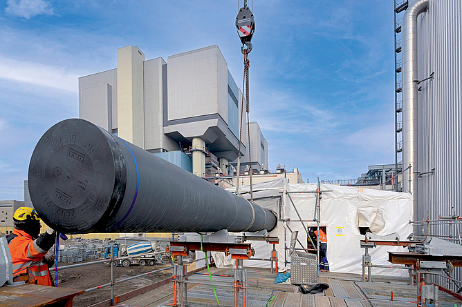 Installation der Rohrleitungen mithilfe eines Krans im Kraftwerk Reuter West.