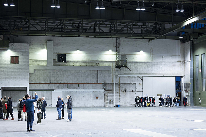 Einzelne Gruppen, verteilt in einer großen Halle. 