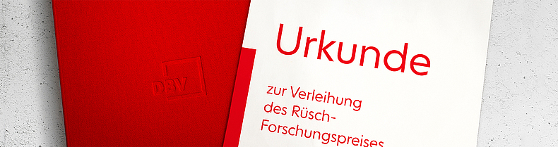 Rote Mappe mit DBV-Logo und Urkunde zur Verleihung des Rüsch-Forschungspreises.