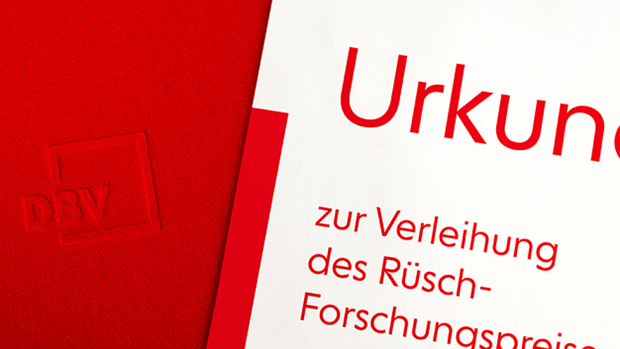 Rote Mappe mit DBV-Logo und Urkunde zur Verleihung des Rüsch-Forschungspreises.