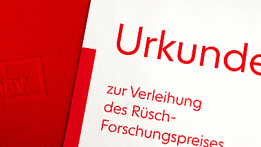 Rote Mappe mit DBV-Logo und Urkunde zur Verleihung des Rüsch-Forschungspreises.