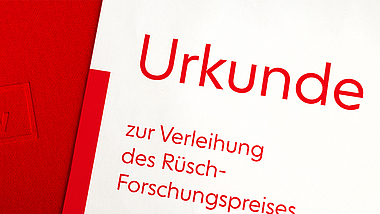 Rote Mappe mit DBV-Logo und Urkunde zur Verleihung des Rüsch-Forschungspreises.