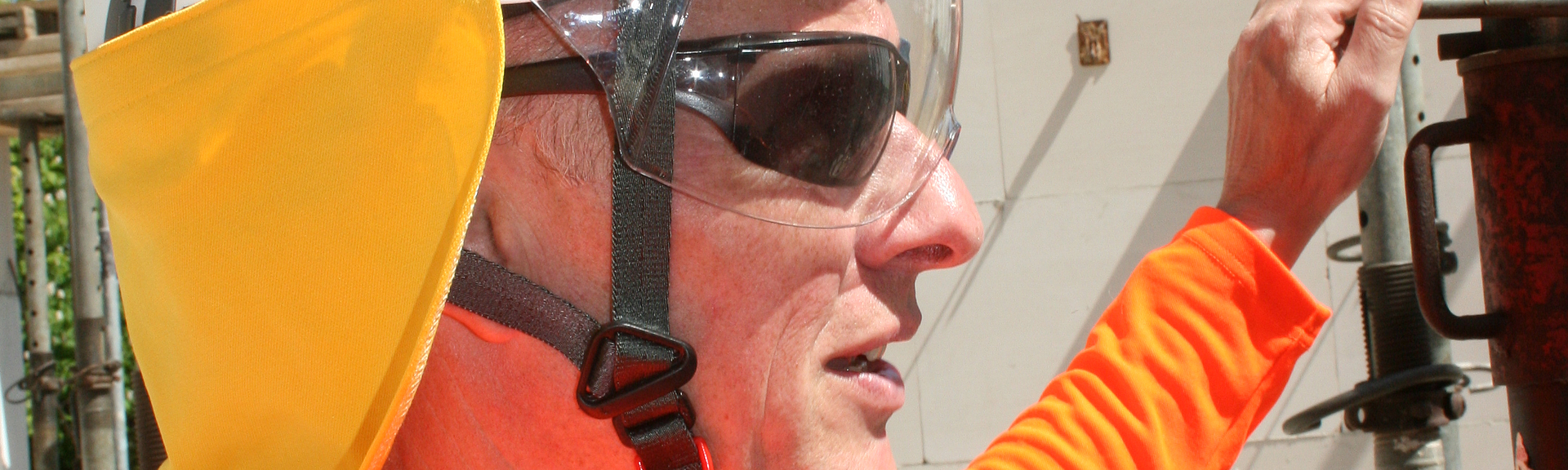 Person in UV-Schutzkleidung Eine Person mit UV-Schutzkleidung steht auf einer Baustelle.