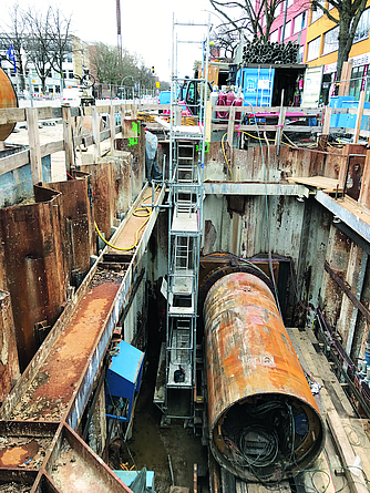Schacht mit Rohrteil in der Mitte, an der Seite befindet sich ein Gerüst mit innenliegendem Leiteraufstieg