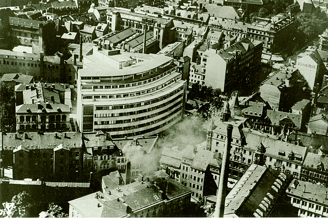 Historische Schwarz-Weiß-Luftaufnahme zeigt ein halbrundes mehrstöckiges Haus inmitten der gründerzeitlichen Bebauung.