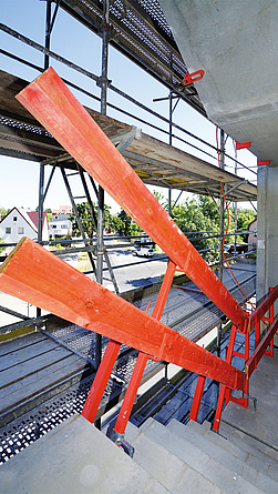 reppenbereich der Baustelle mit roten Absturzsicherungen.