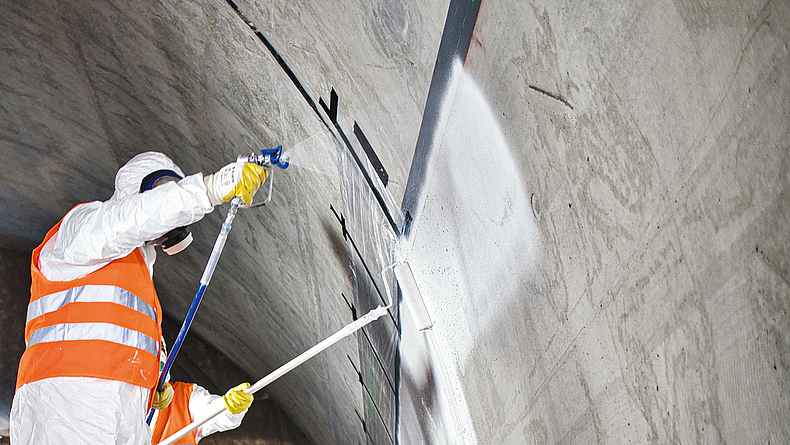 Person dichtet Tunnelbauwerk ab.