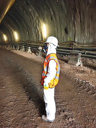 Seitenansicht: Ein Beschäftigter im Brandbergtunnel in persönlicher Schutzausrüstung.