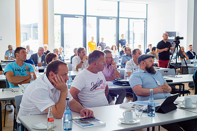 Blick auf Teilnehmende des Zukunftstages, die an Tischen sitzen.