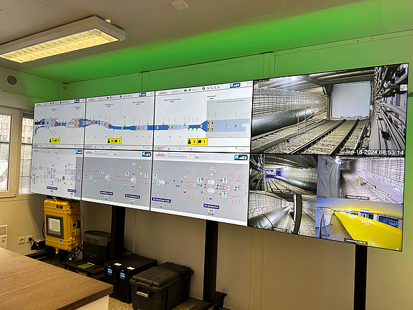 Zentraler Leitstand zur Anzeige aller Messdaten, zur Steuerung der Ventilatoren im Baufeld sowie zur Darstellung der Personenortung Leitstand mit acht Monitoren zeigt Bilder und Messdaten von verschiedenen Standorten.